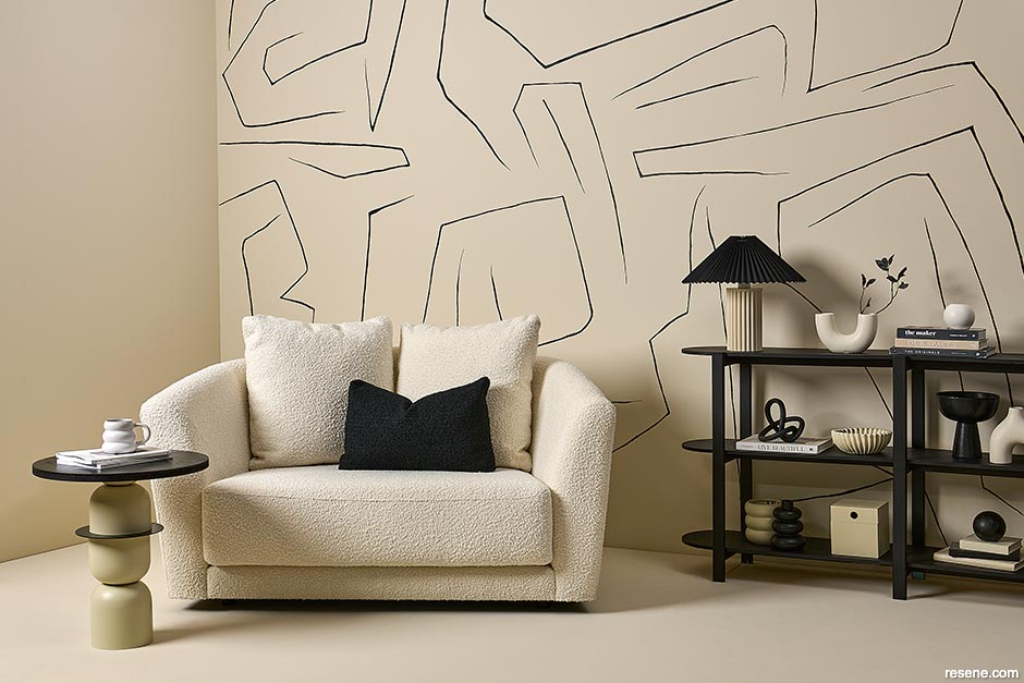 A neutral living room with a simple line mural