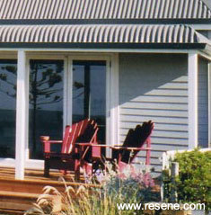 Resene Acorn was used on window frames and Resene Lumbersider tinted to Resene Spanish White on window surrounds