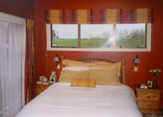 Master bedroom in Resene Tamarillo and Resene Spanish White Paint