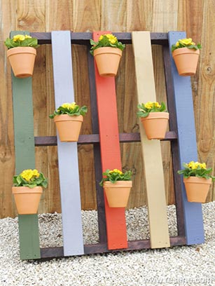 Build a colourful pallet hanger for your garden pots