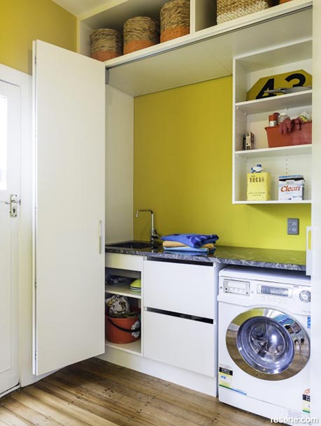 A laundry room with sunny yellow walls