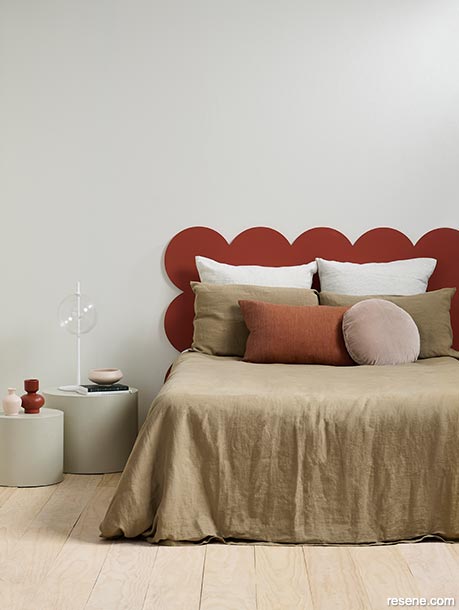 A neutral bedroom with a painted headboard