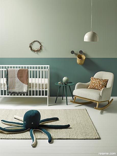 A nursery with chalky grey floors and green-blue walls
