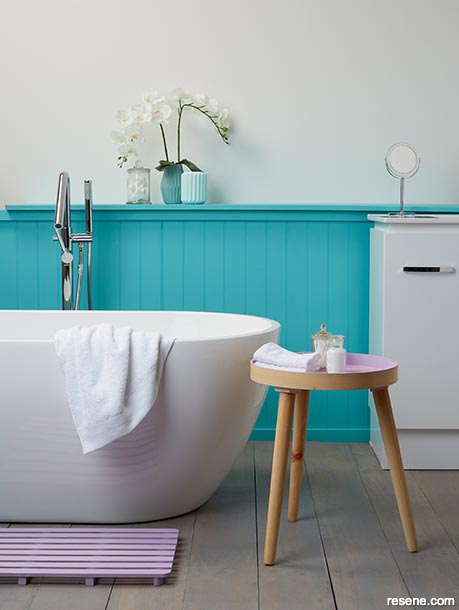 A bathroom painted with bright turquoise and touches of pink