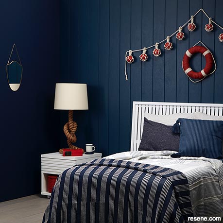 A deep blue nautical themed bedroom