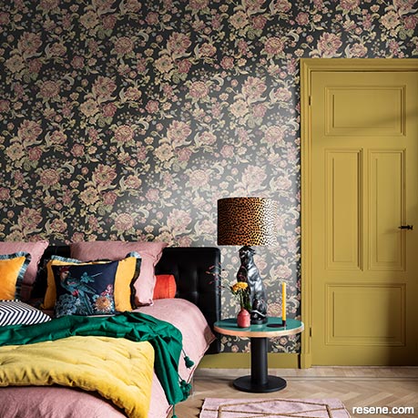 A bedroom with a floral wallpaper pattern