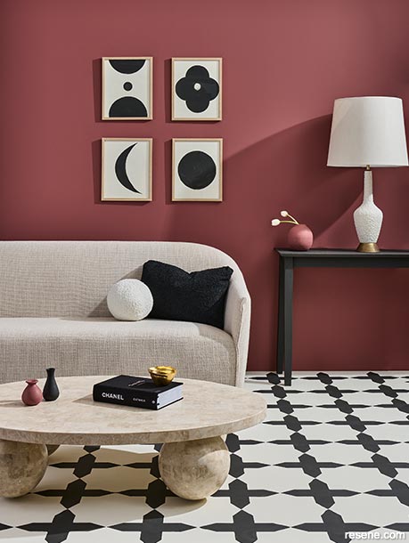 A lounge with wine red walls and cream and black floors