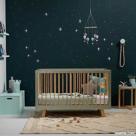 A nursery with a painted night sky backdrop