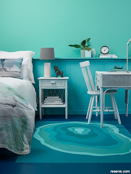 An aqua bedroom with a painted rug feature