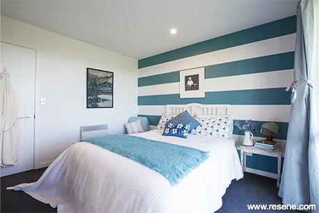 A blue and white striped bedroom feature wall