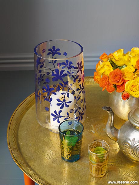 A glass vase with a blue stencil design