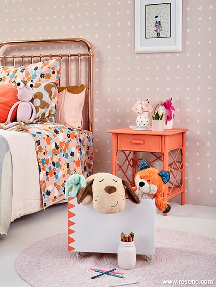 A blush childrens room with a pop of orange