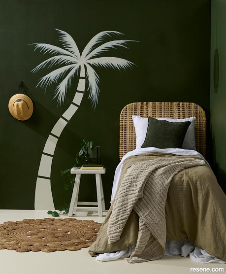 A small bedroom with a palm tree mural