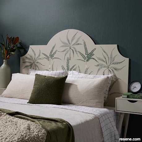 A headboard painted with fern and leaf details