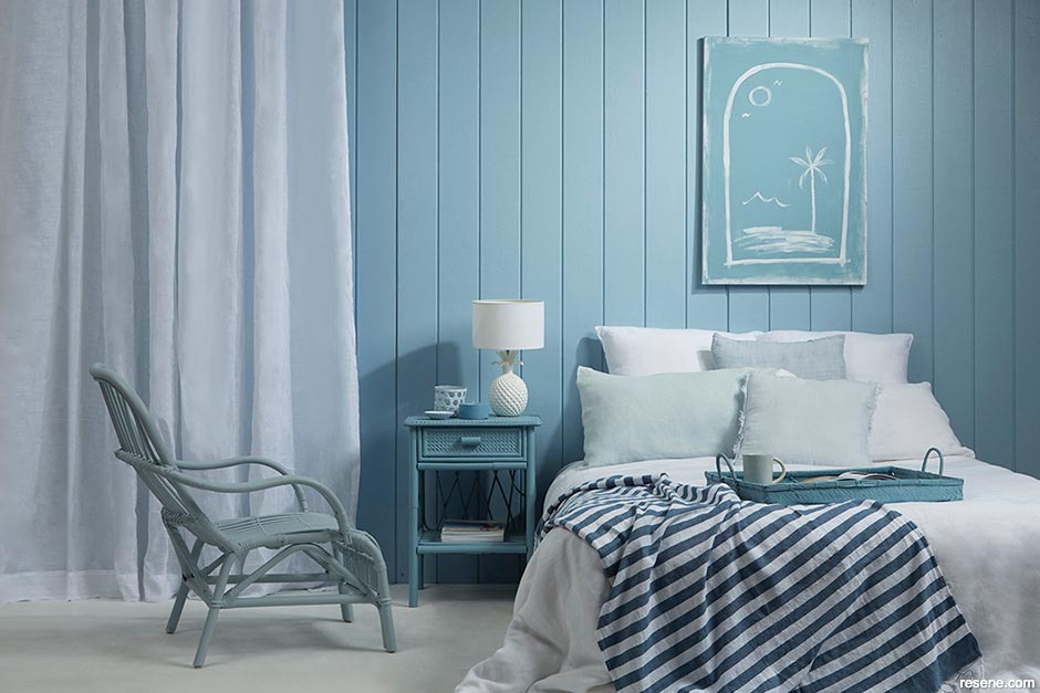 A bedroom with a coastal blue and white colour scheme
