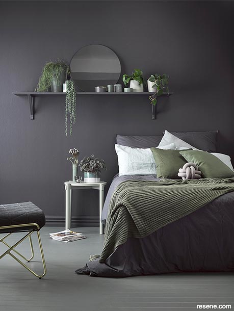A dark grey bedroom with green and white accents