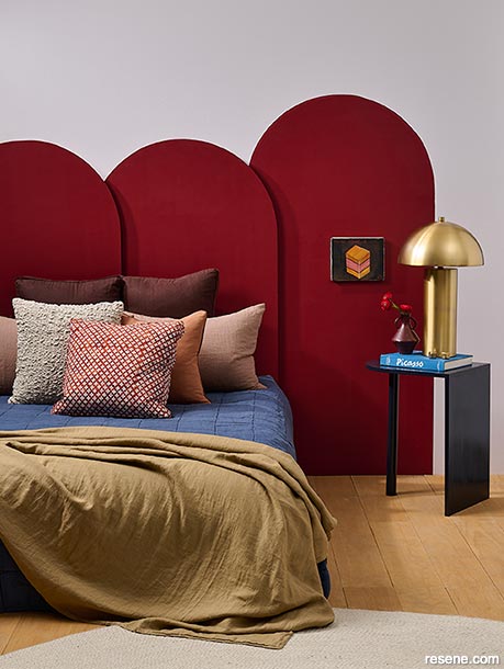 A bedroom with a dark red headboard