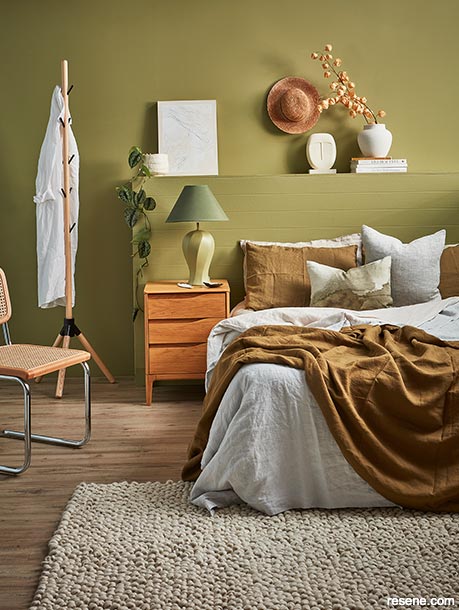 An earthy green bedroom against wood tones