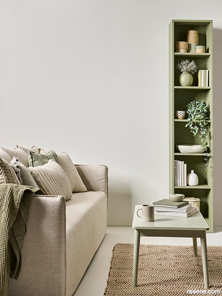 A neutral lounge with green accessories