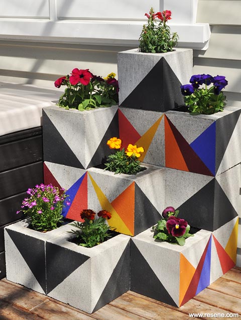 A painted concrete block planter in geometric shapes