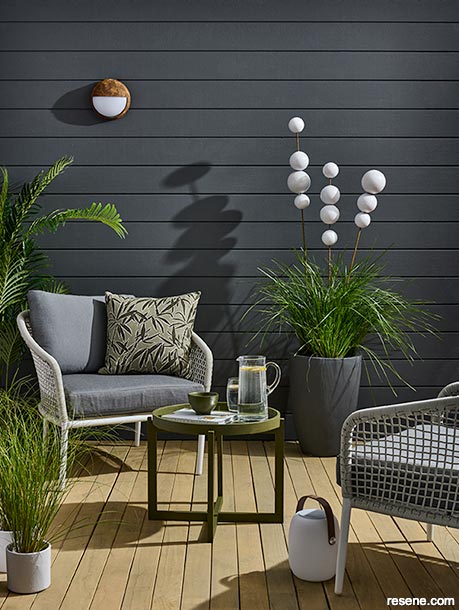 A charcoal exterior wall in a deck/patio area