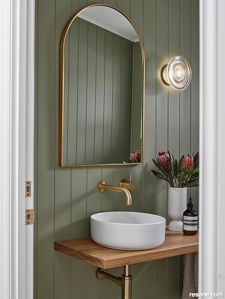 A relaxed tropical green powder room painted in Resene Flax