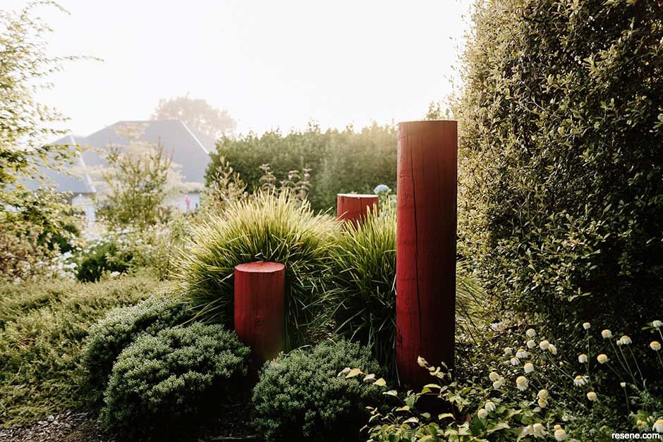 Red posts paint in Resene Rock N Roll provide contrast to the greenery