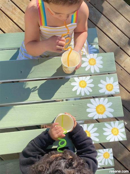 A refurbished picnic table with painted daisies
