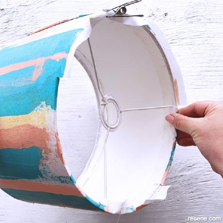 Fold and glue fabric over the edge of the lampshade