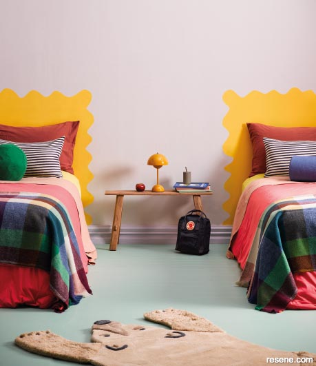 An artsy kids bedroom with squiggly painted headboards