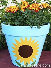 Paint a sunflower design on a garden pot
